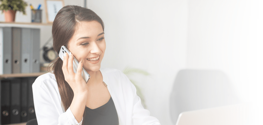 Une personne souriante en conversation téléphonique avec un conseillé pédagogique ALTI TRADING